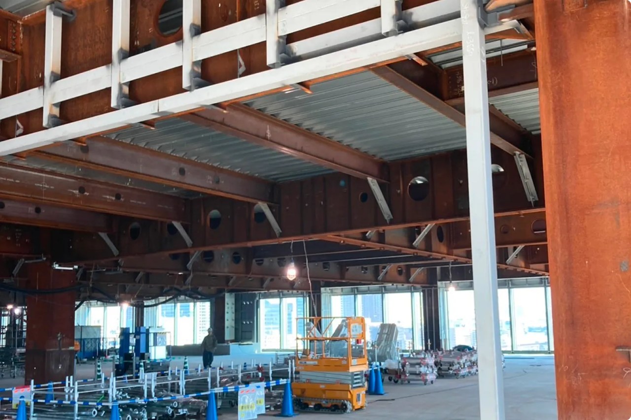 構造体の複雑なディテール：鋼材の継ぎ目、開口部、未完成の天井を見上げる視点。